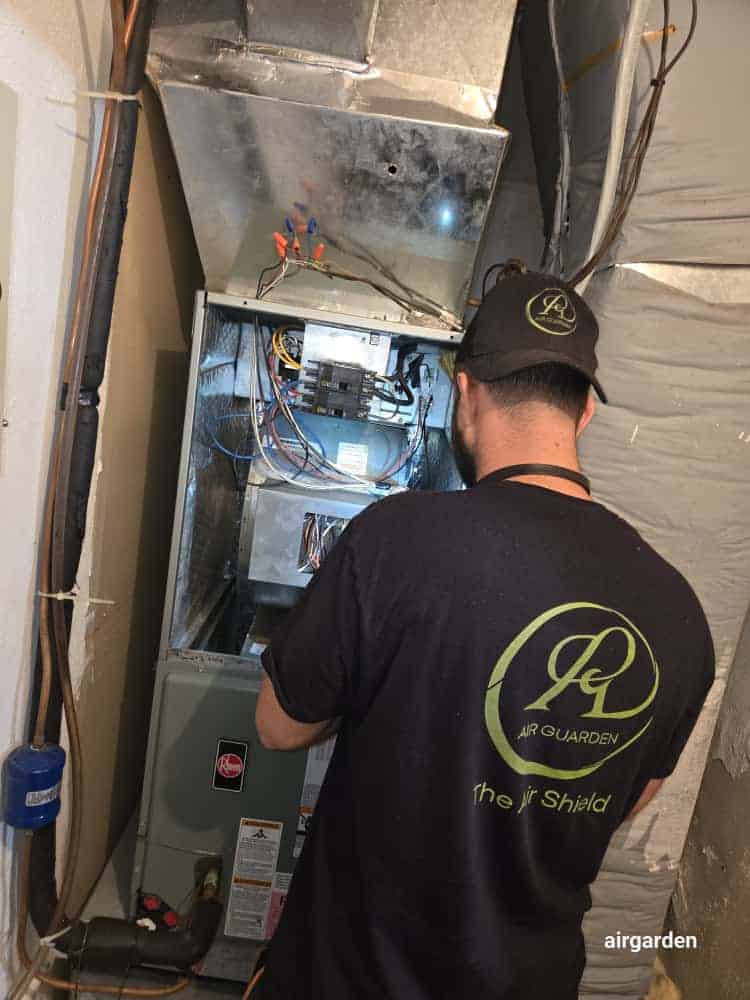 Technician inspecting HVAC air handler during duct cleaning service